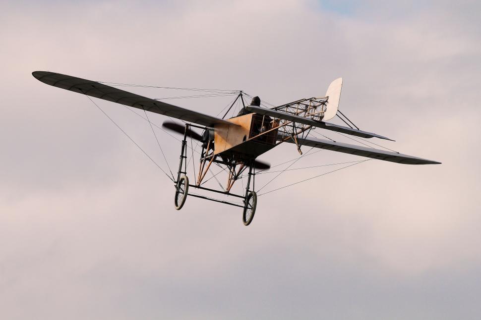Free Image of Vintage biplane flying against cloudy sky 