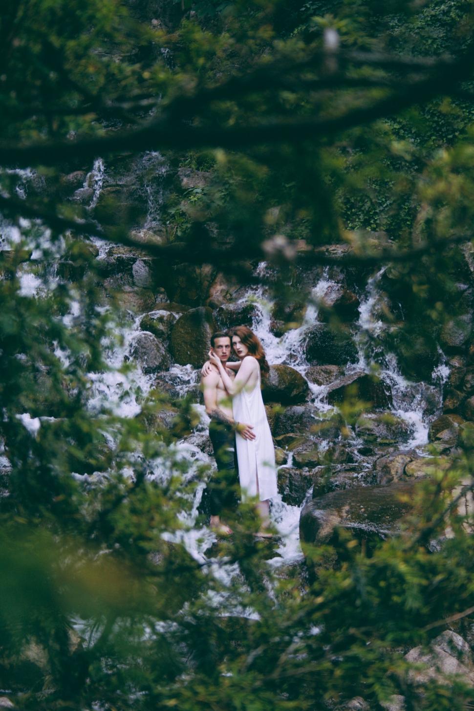 Free Image of Couple embracing near waterfall 