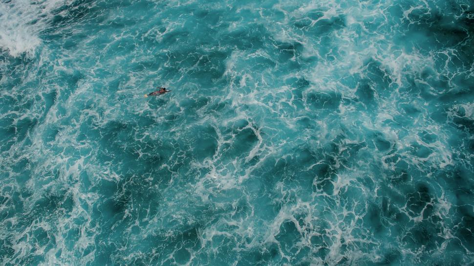 Free Image of Surfer amidst rough turquoise ocean waves 