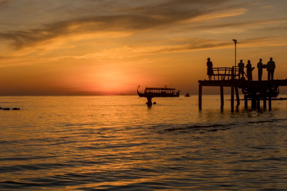 Free Image of Sunset at sea with people on pier 