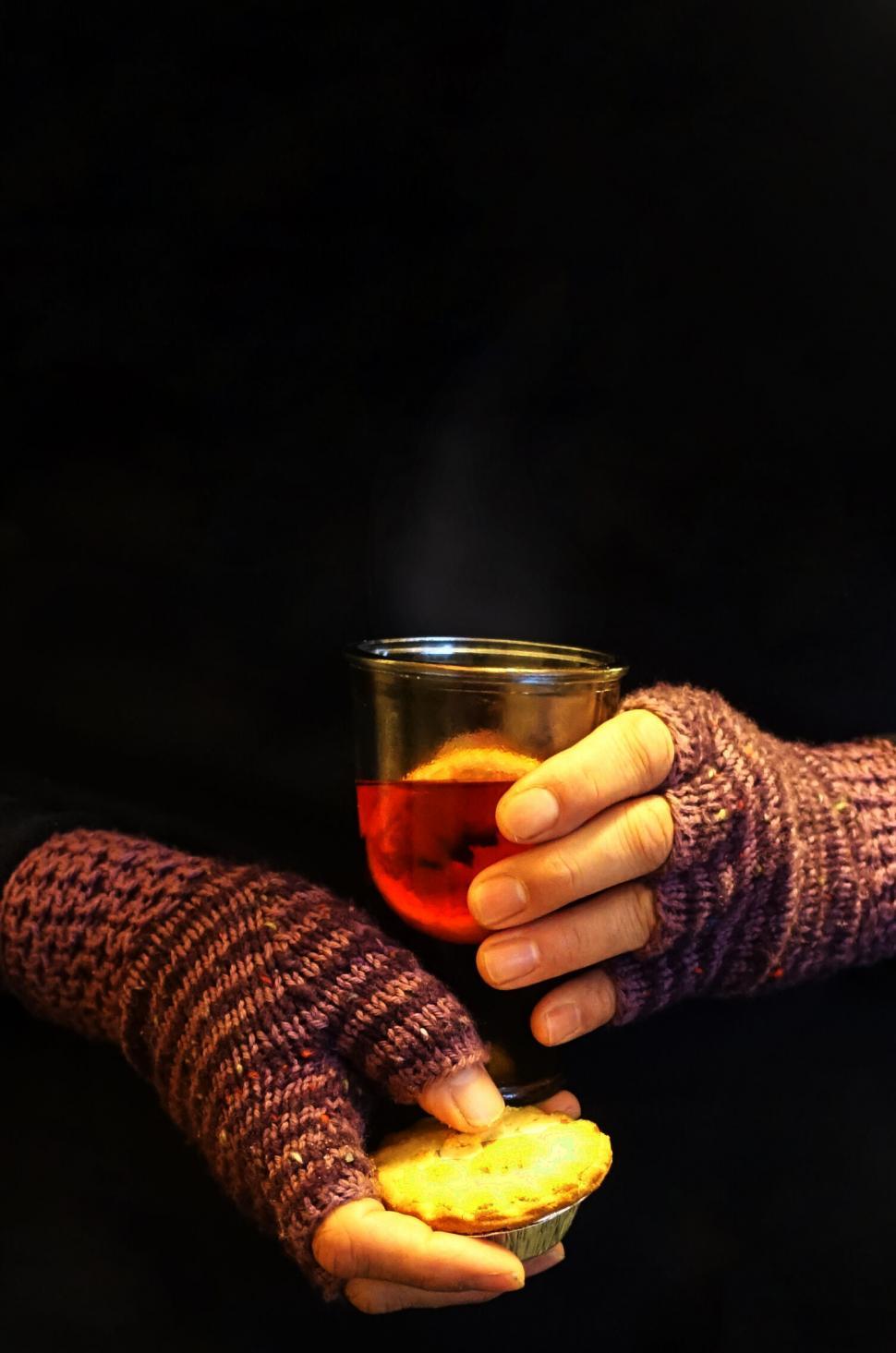 Free Image of Hands holding tea and cookie in warmth 