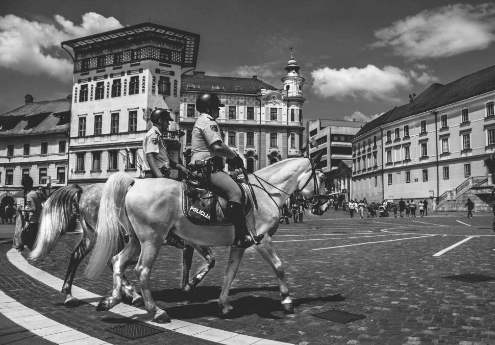 Free Image of Mounted police patrolling a city square 
