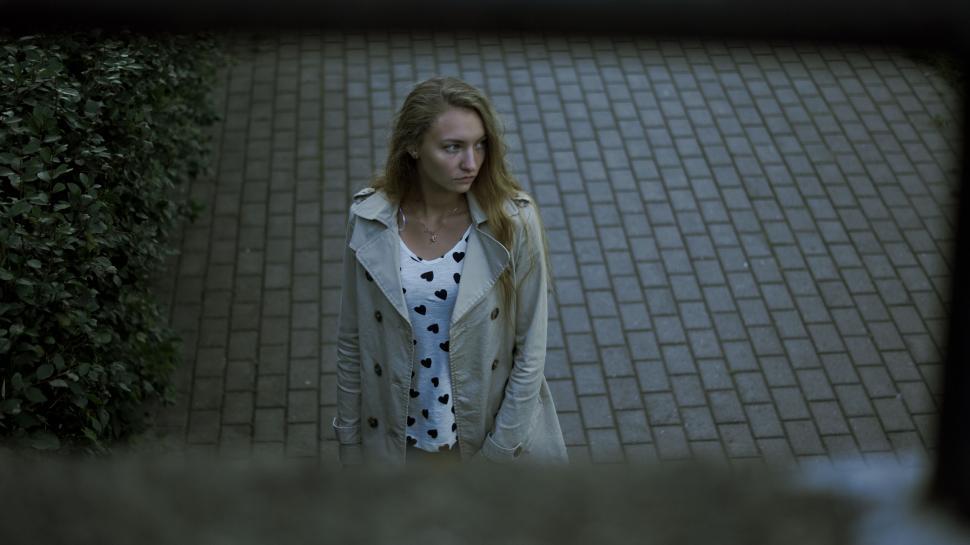 Free Image of Woman framed by leaves in a dark setting 
