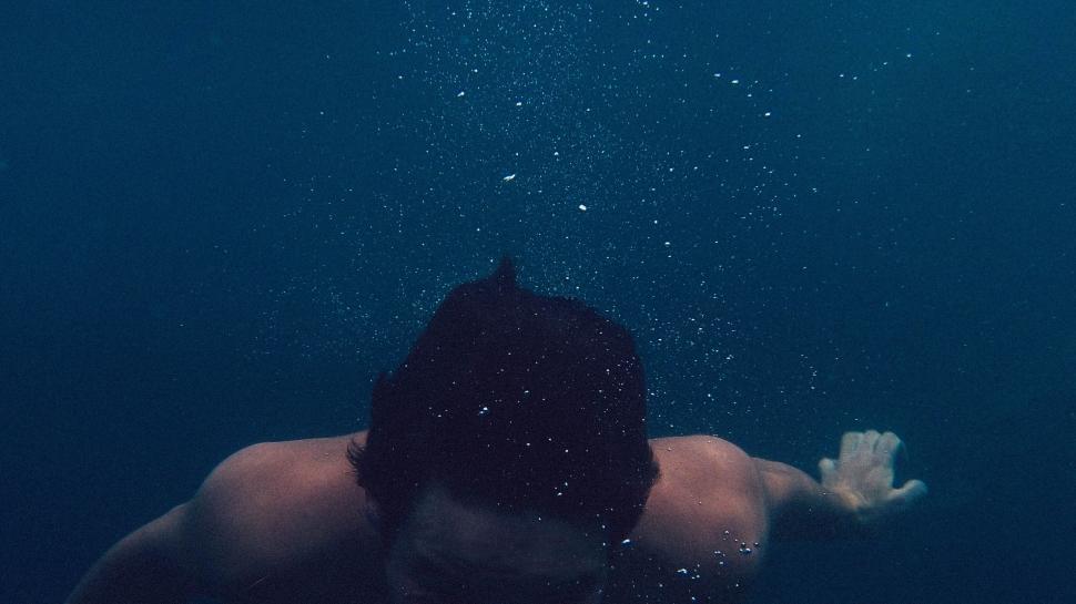 Free Image of Person diving underwater with bubbles 