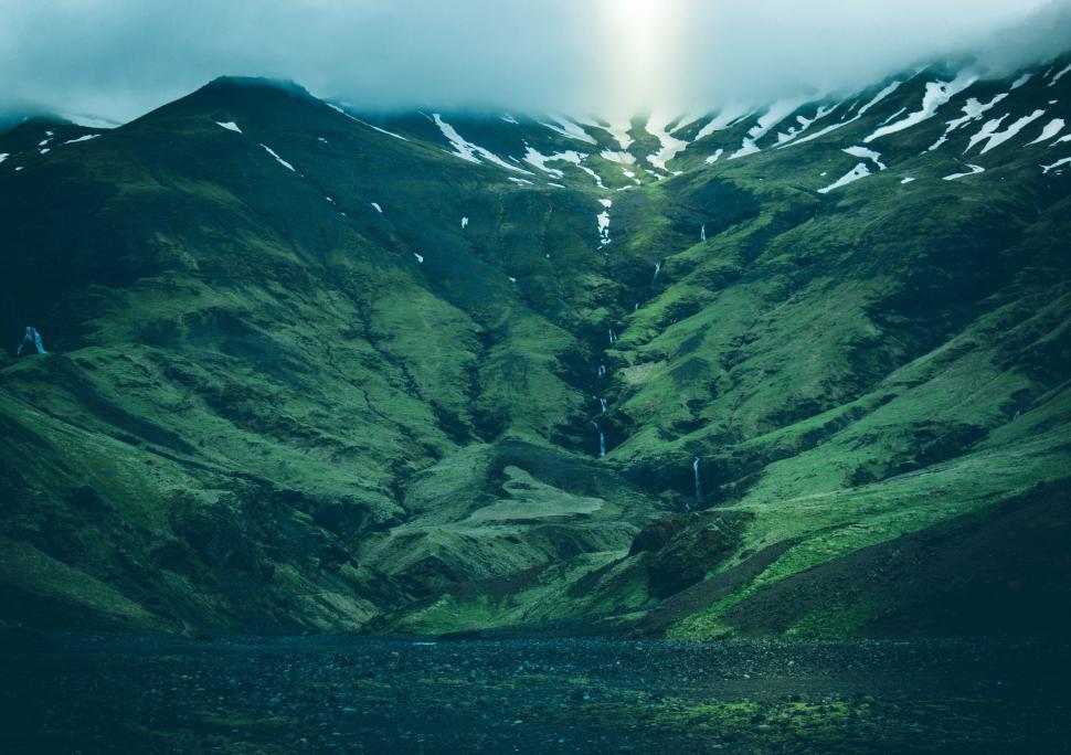Free Image of Lush green valley with waterfalls and mist 