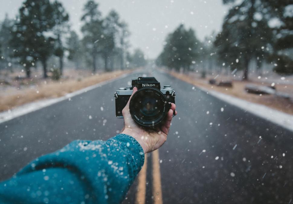Free Image of Camera held in a snowy road setting 