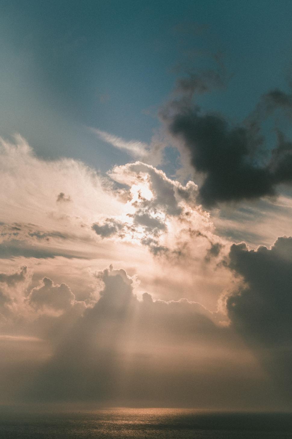 Free Image of Sunset rays piercing through clouds 