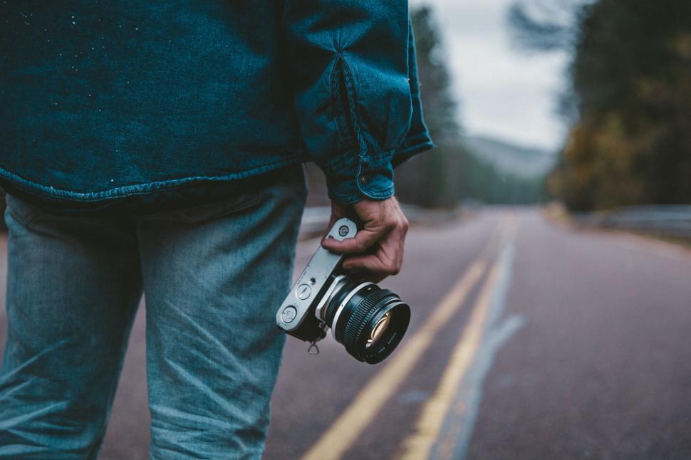 Free Image of Person holding a vintage camera on road 