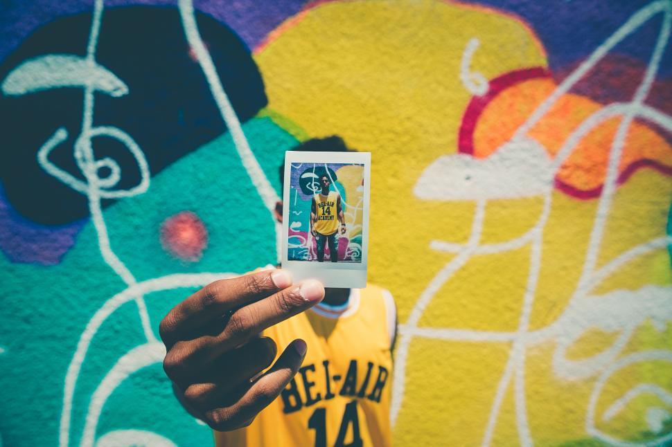 Free Image of Hand holding card with graffiti background 
