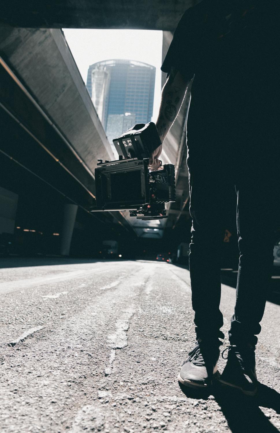 Free Image of Urban photographer holding camera on street 