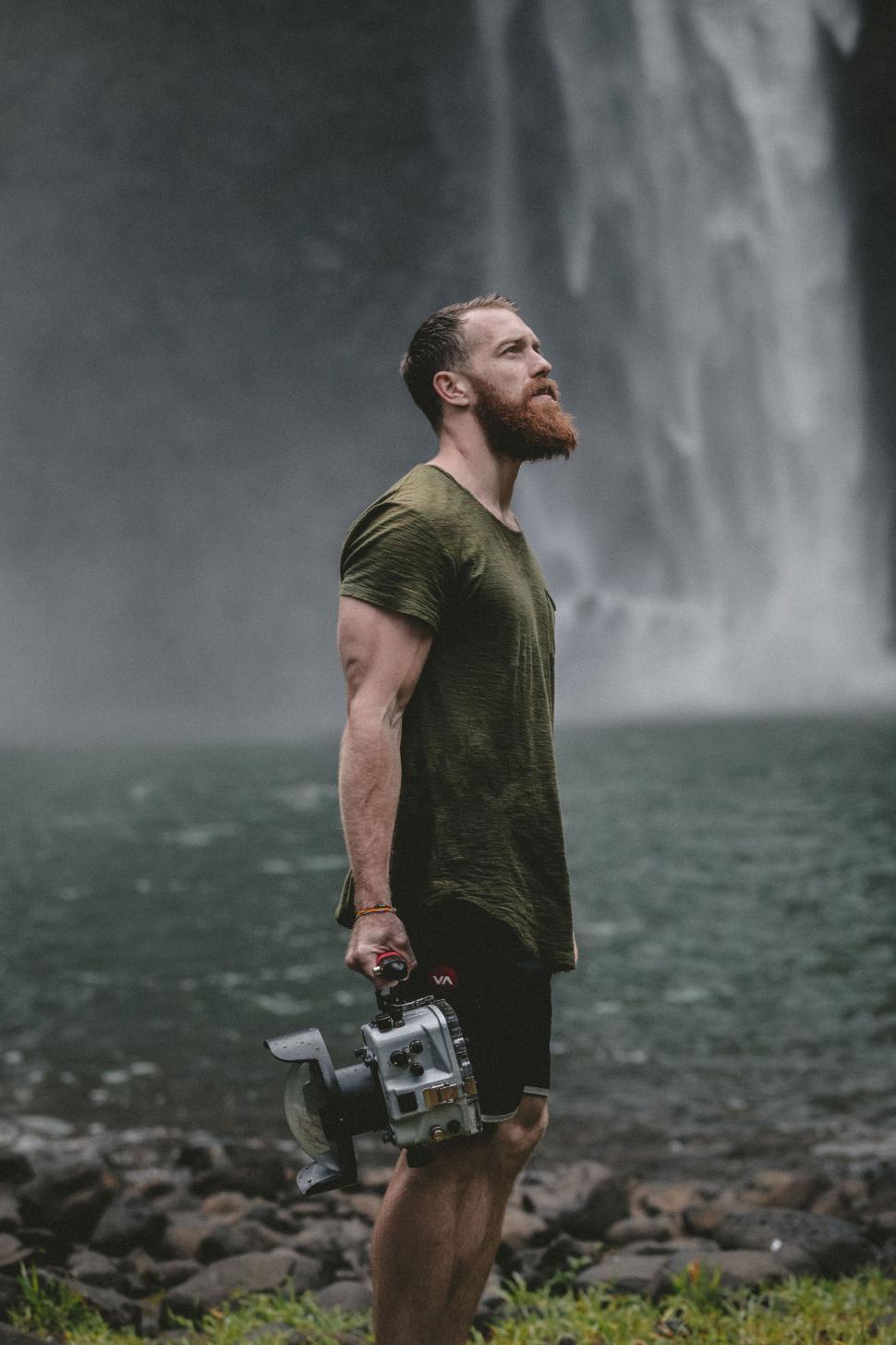 Free Image of Man with camera in front of waterfall 