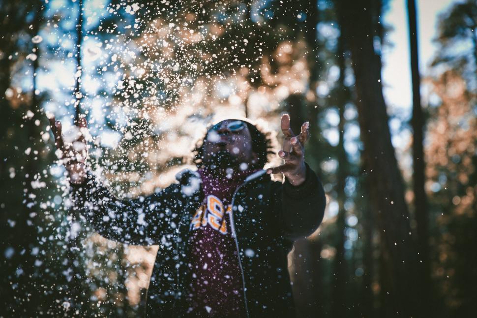 Free Image of Person in nature with hands in falling snow 