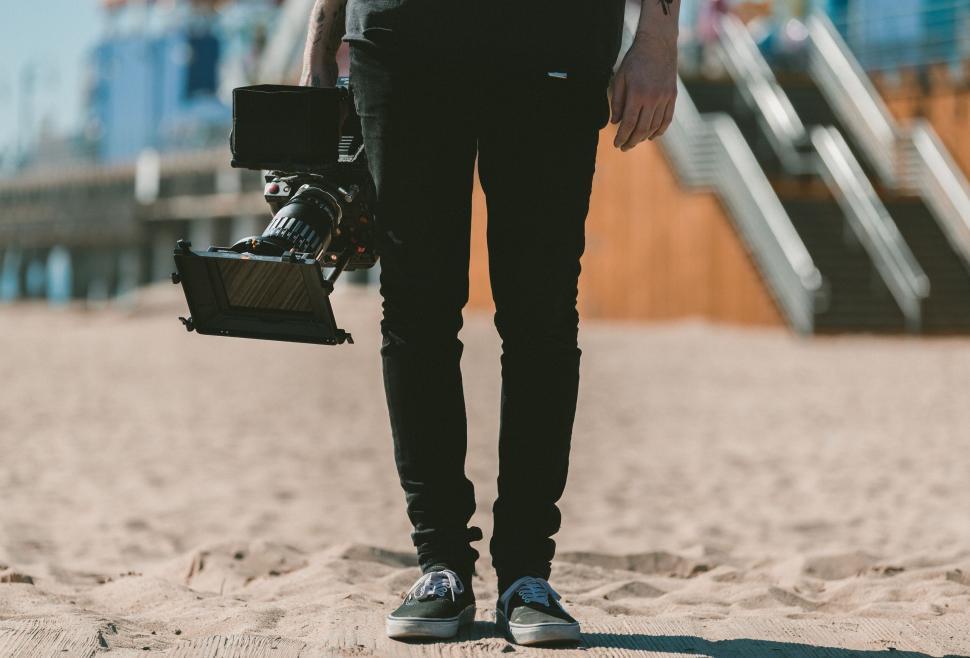 Free Image of Filmmaker with camera rig at beach 