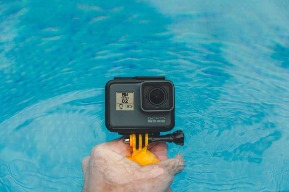Free Image of Hand holding an action camera in pool 