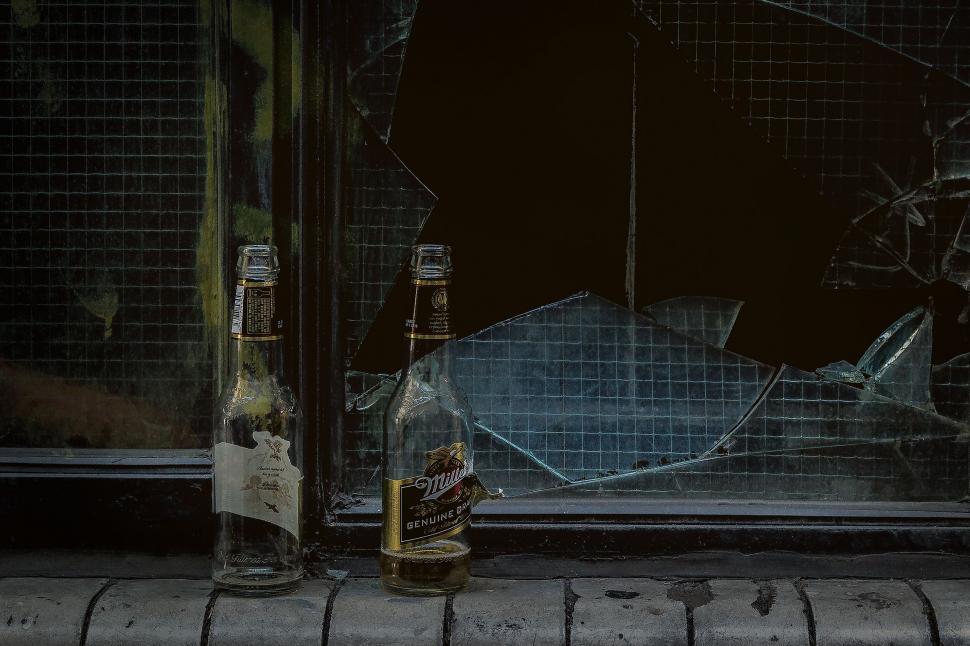 Free Image of Empty beer bottles and broken window 