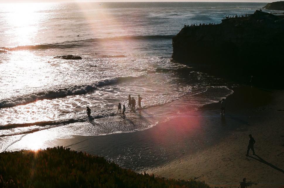 Free Image of Beach scene at sunset with people 