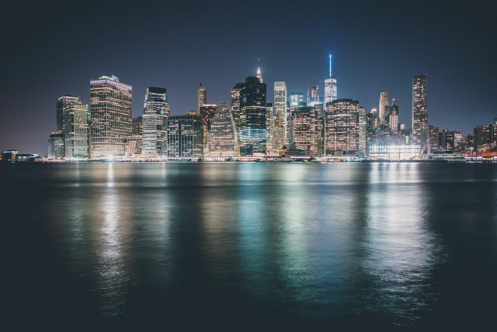 Free Image of City skyline reflected on waterfront at night 