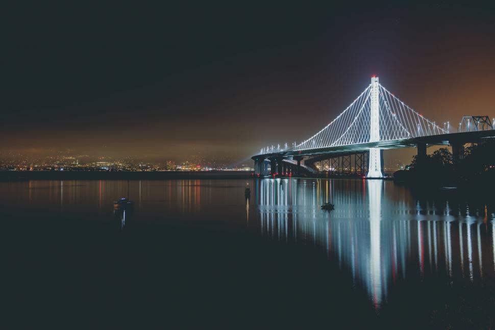 Free Image of Illuminated bridge over still water at dusk 