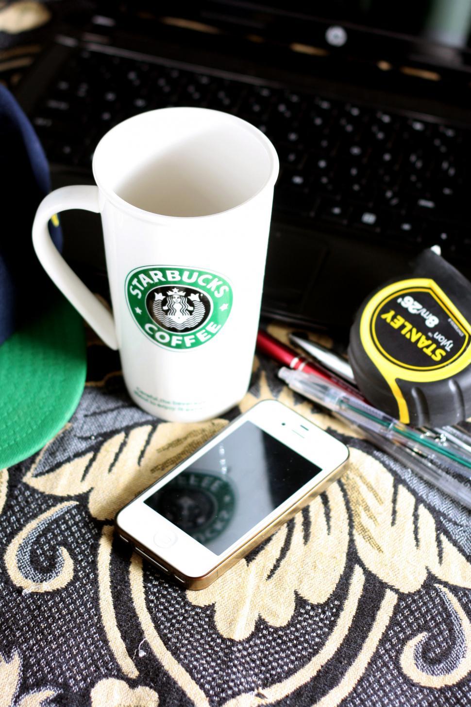 Free Image of Coffee mug with phone on decorated table 