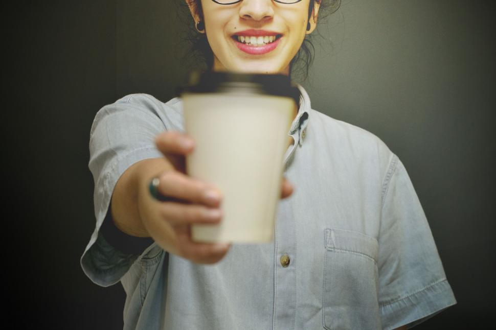 Free Image of Person offering a coffee cup forward 