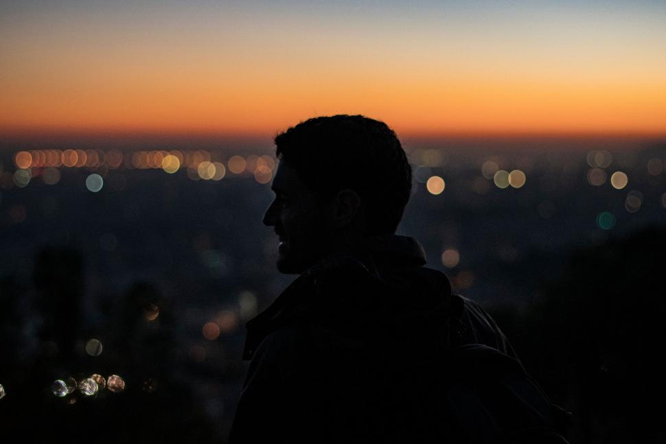 Free Image of Man silhouette against city sunset 
