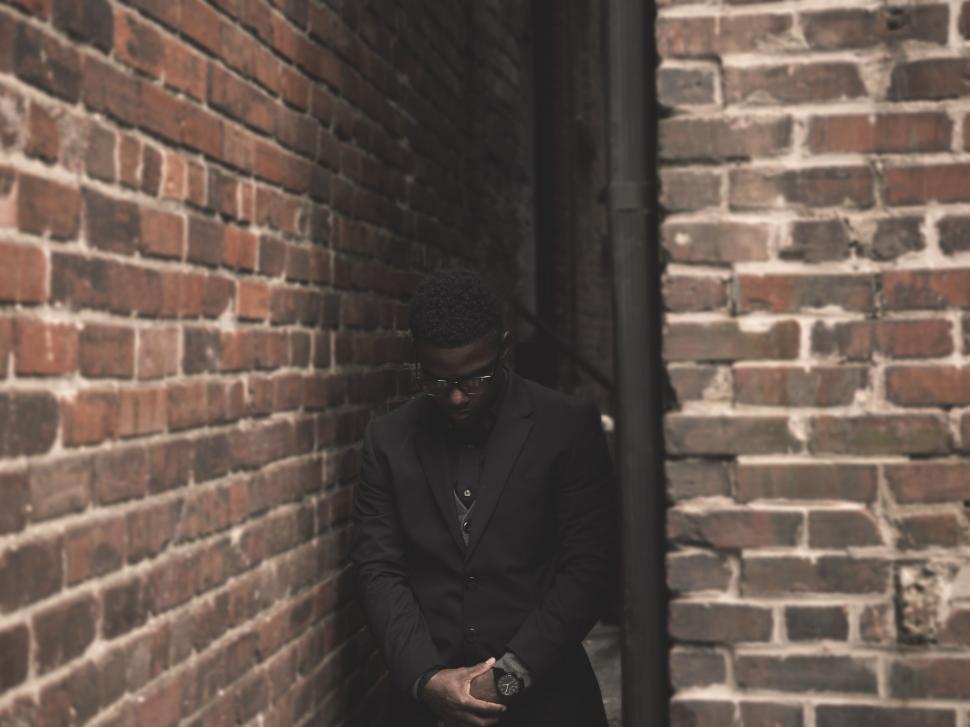 Free Image of Businessman in a dark alley with brick walls 