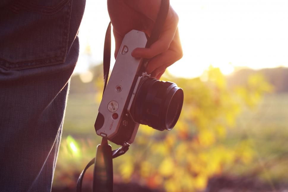 Free Image of Person holding a camera at sunset 