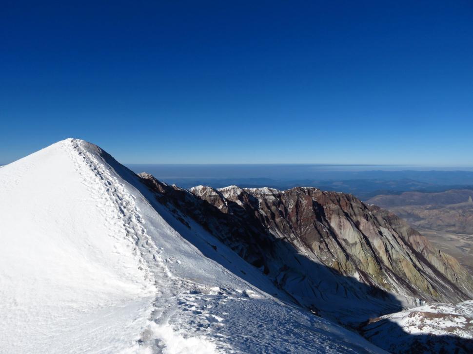 Free Image of Snowy mountain trail with clear skies 
