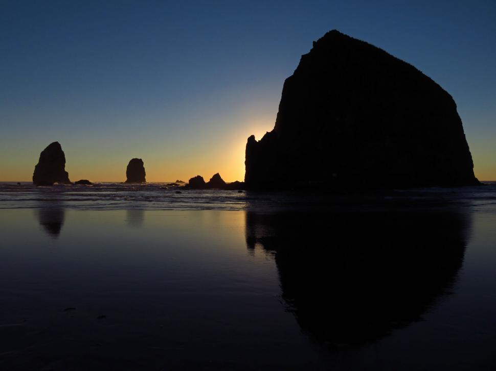 Free Image of Sunset silhouette of rocky coastal formations 