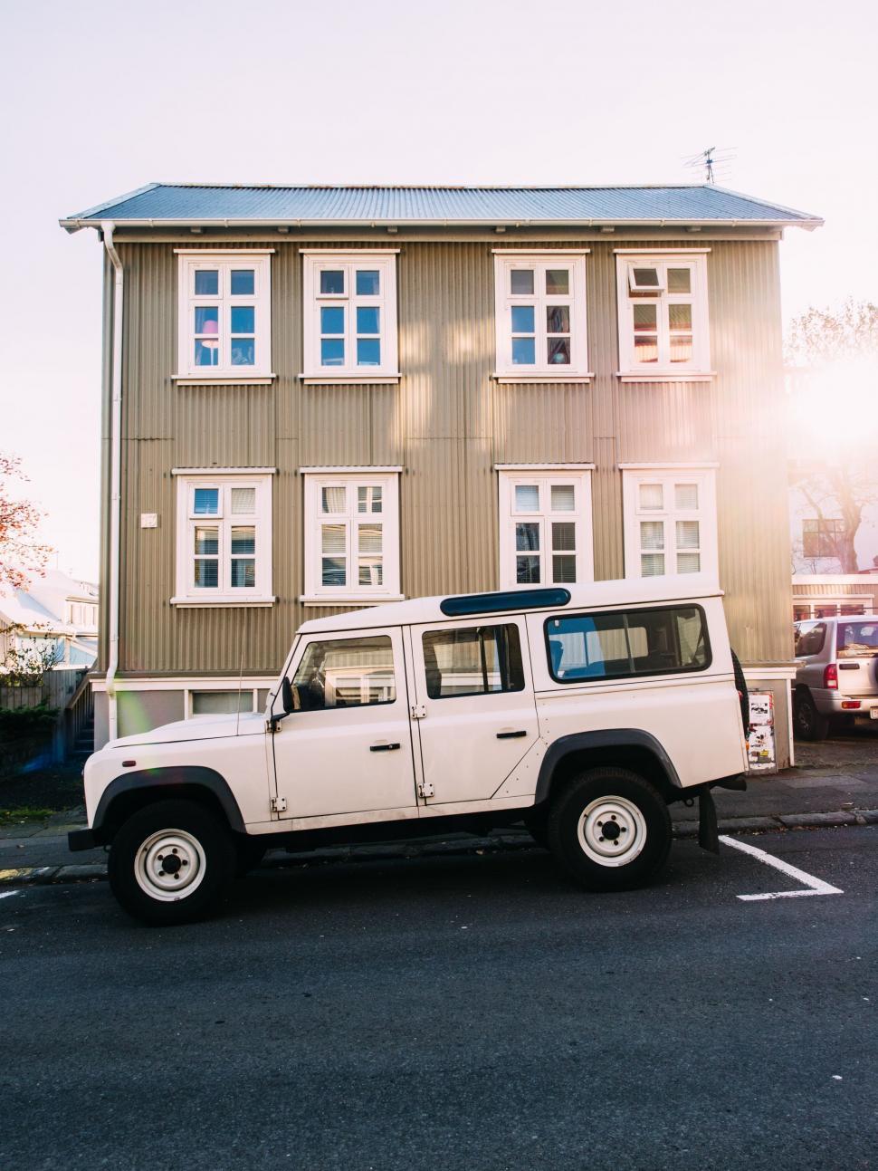 Free Image of Off-road vehicle parked in front of a house 
