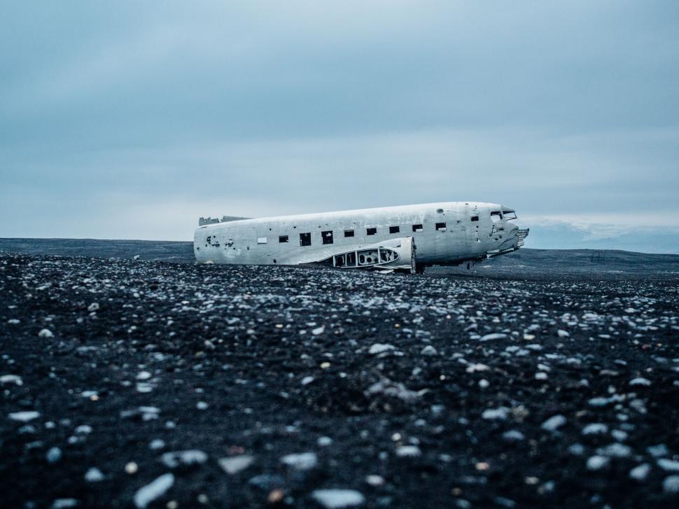 Free Image of Abandoned airplane wreckage on black sand 