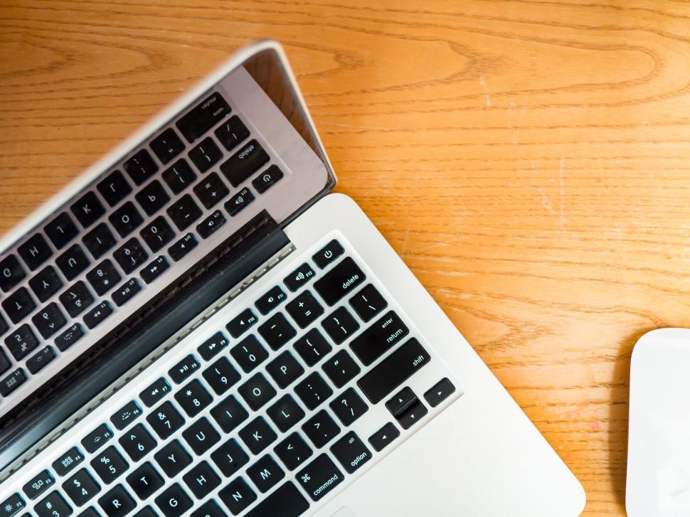 Free Image of Half-closed laptop on wooden desk 