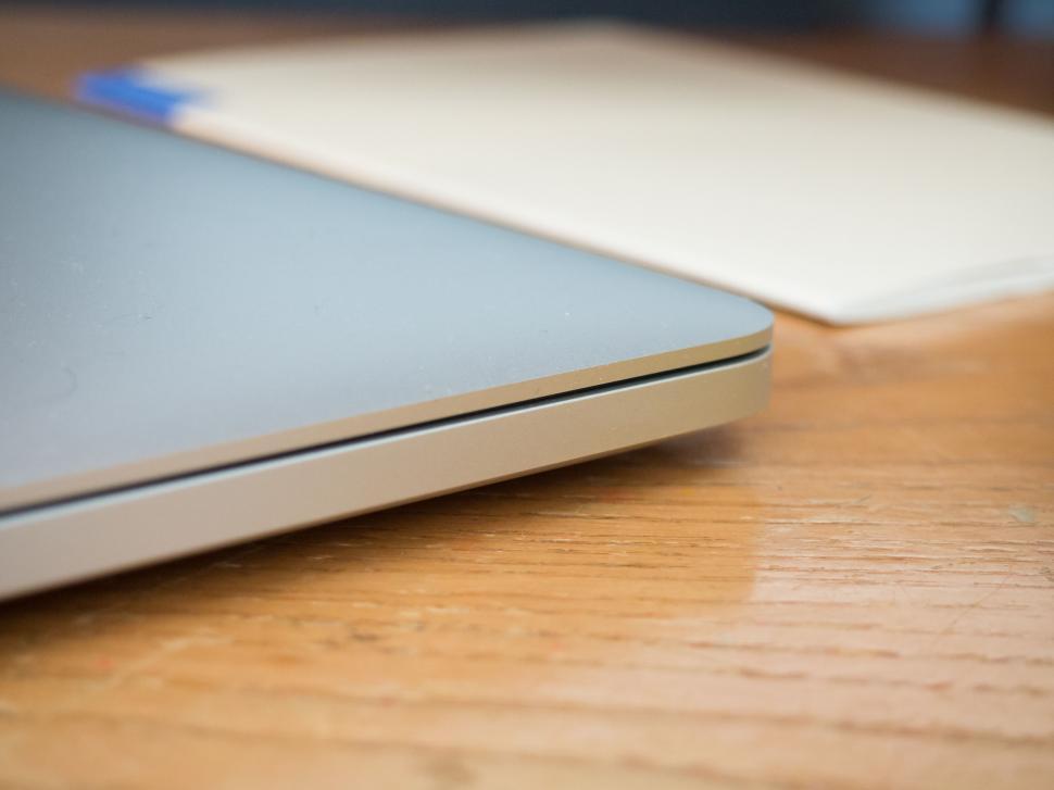 Free Image of Laptop partially closed on a wooden desk 