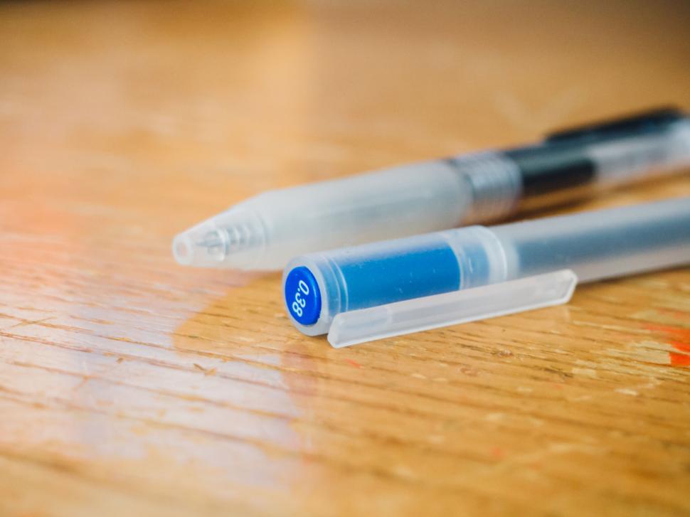 Free Image of Two pens close-up on a worn table 