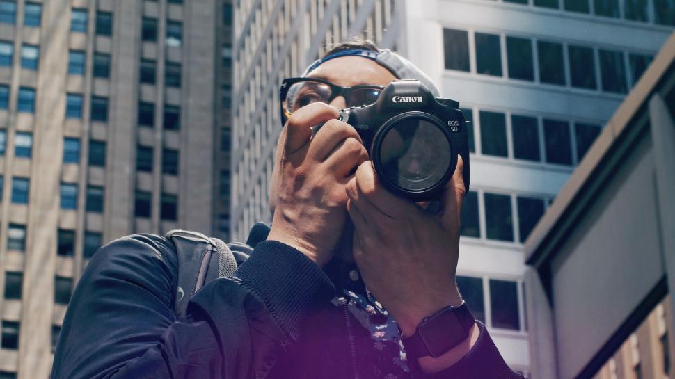 Free Image of Photographer with camera covering his face 