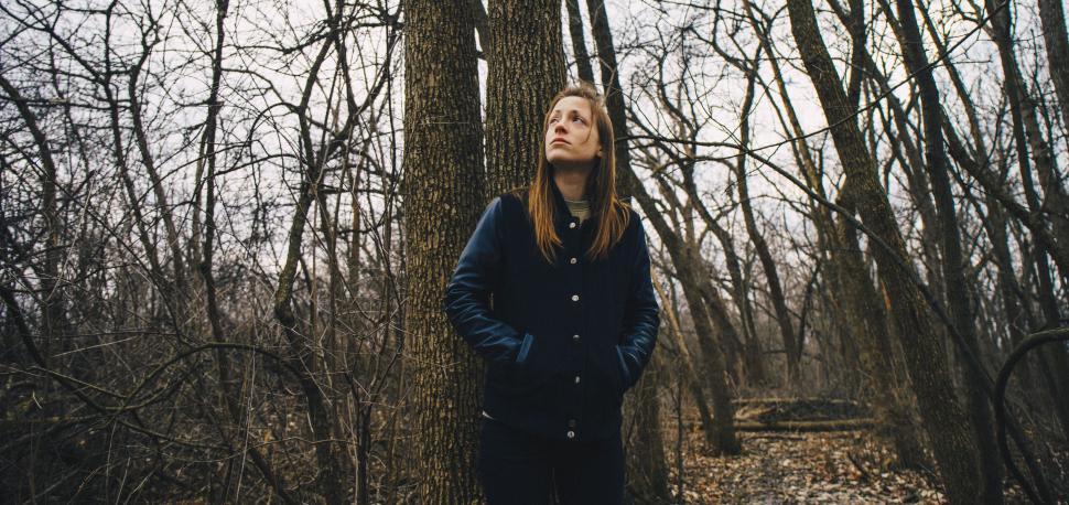 Free Image of Person standing in a forest with blurred face 