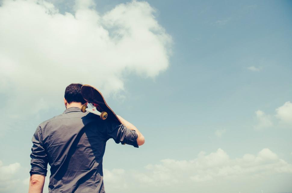 Free Image of Man with skateboard looking up 