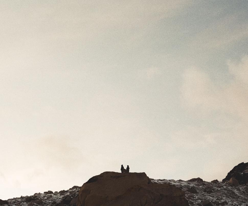 Free Image of Two people sitting on a mountain peak 