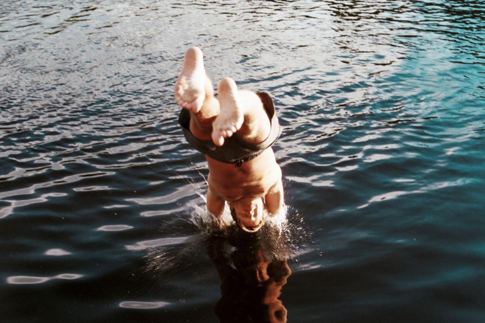 Free Image of Man diving into water from a dock 