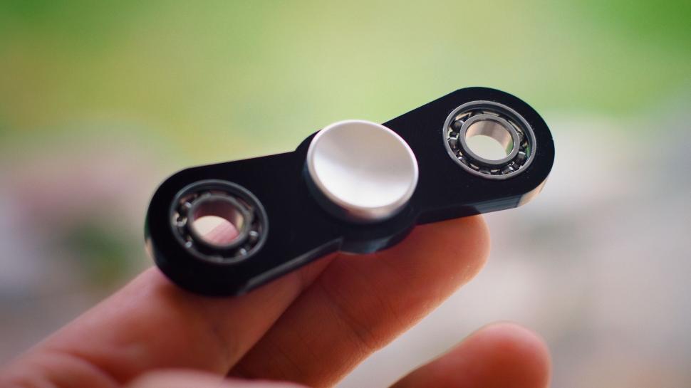 Free Image of Hand holding a black fidget spinner 