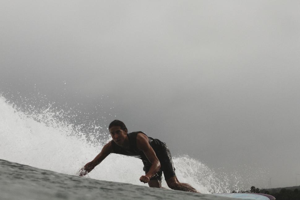 Free Image of Surfer riding wave in overcast weather 