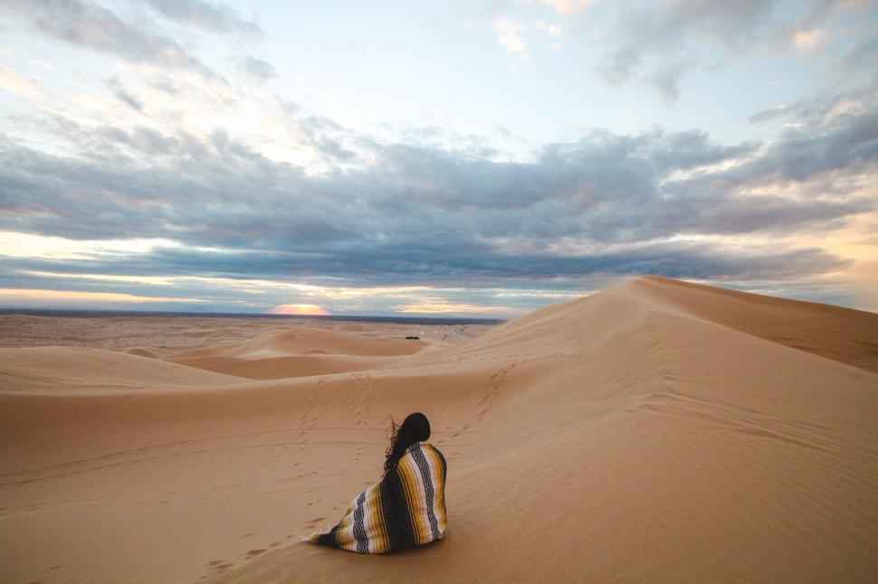 Free Image of Person wrapped in blanket on dune 