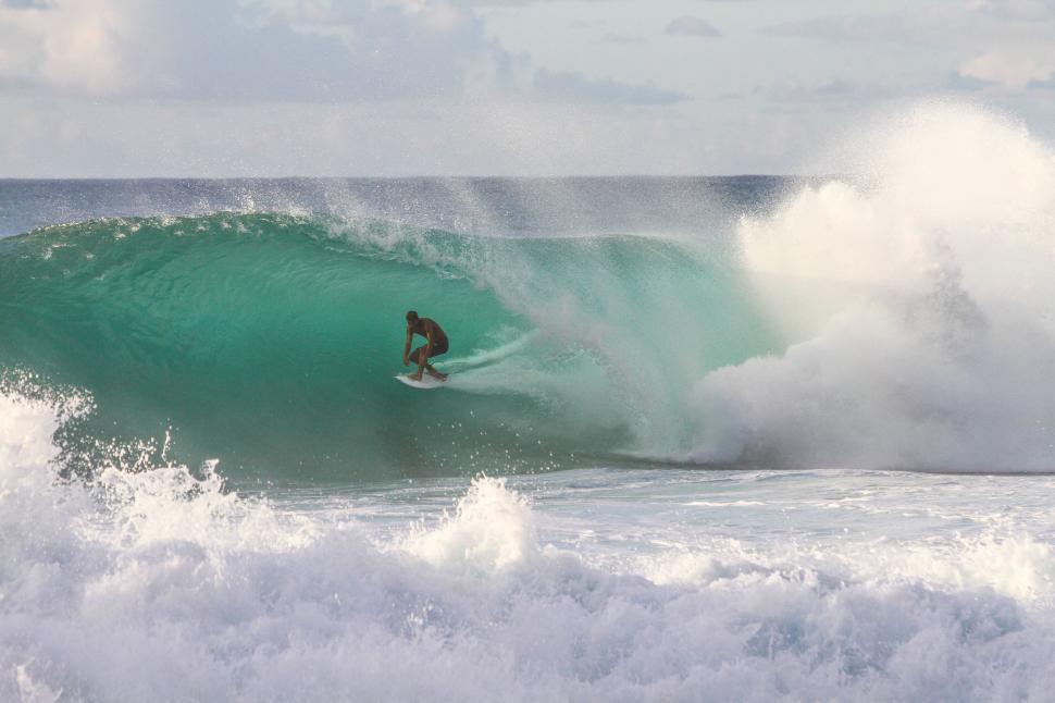 Free Image of Surfer riding a wave in the sea 