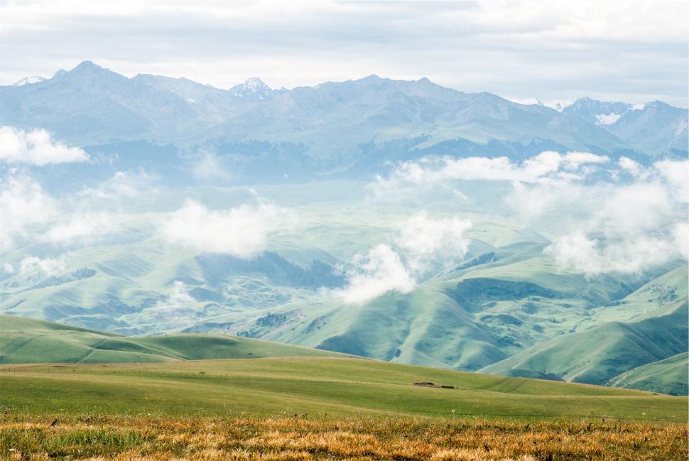 Free Image of Rolling green hills under a cloudy sky 