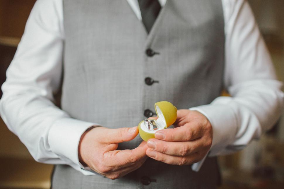 Free Image of Groom holding wedding rings in box 