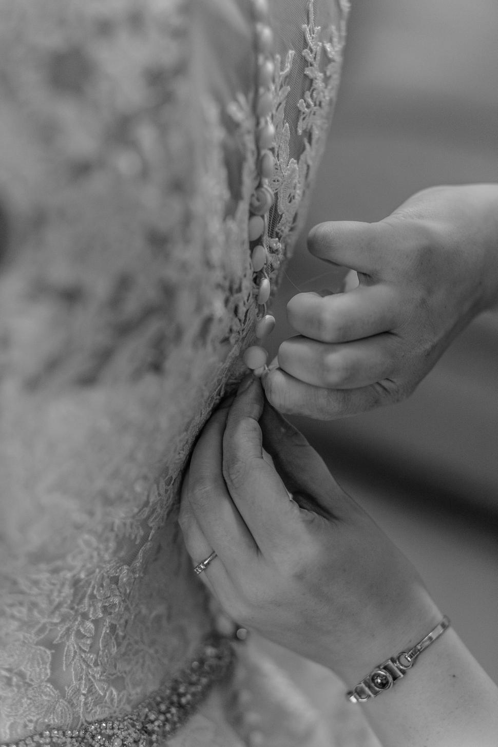 Free Image of Adjusting the bride s wedding dress 