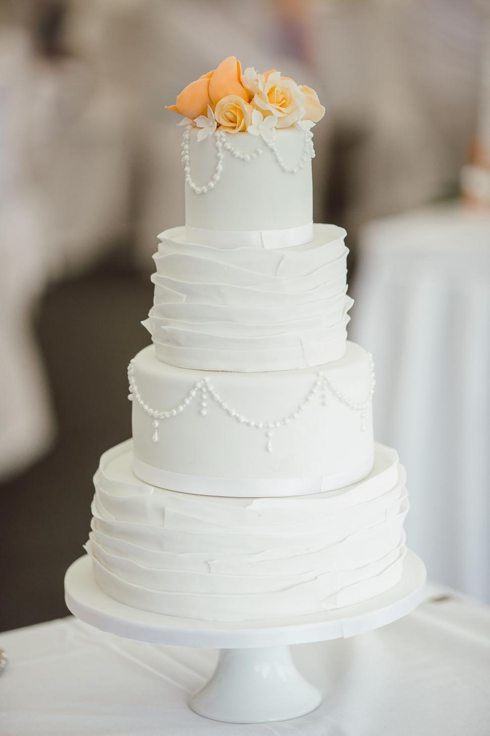 Free Image of Elegant white wedding cake with orange flowers 