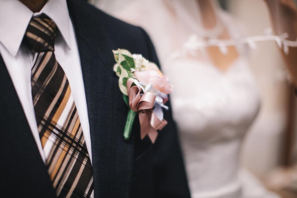 Free Image of Groom with boutonniere and blurred bride 