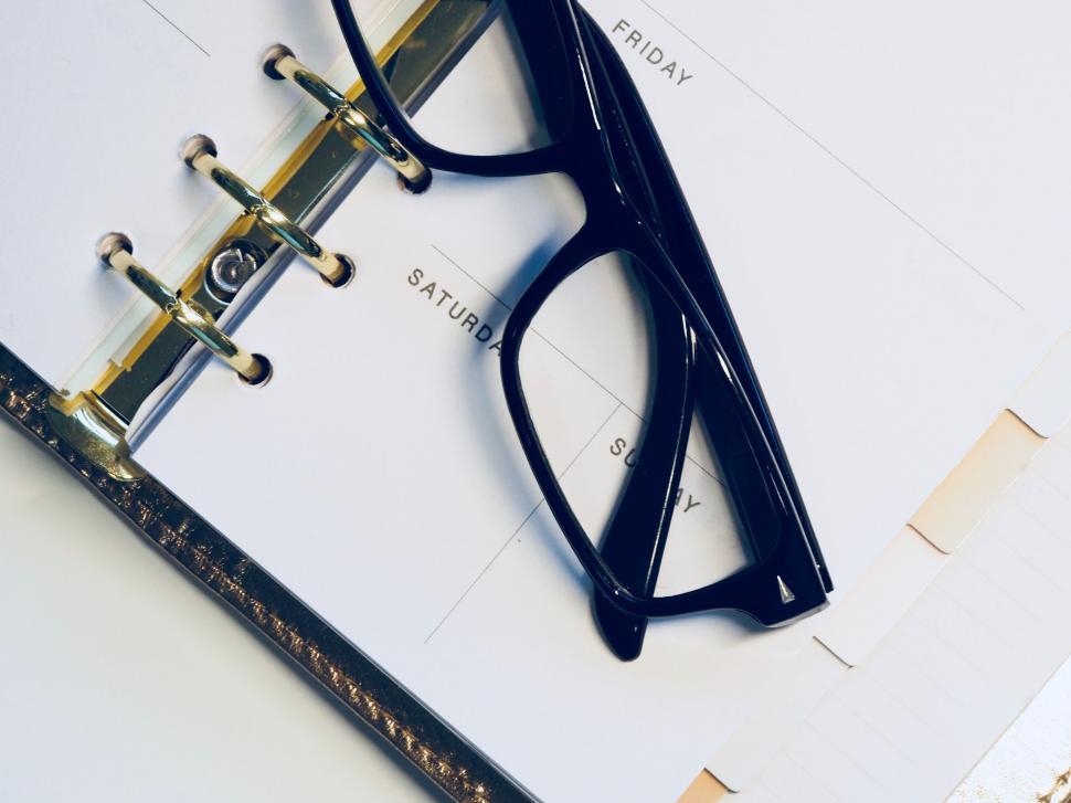 Free Image of Eyeglasses on a planner with Saturday text 