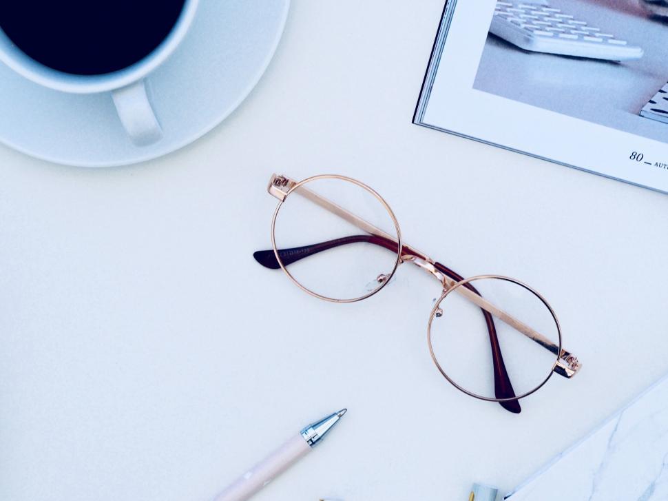 Free Image of Eyeglasses and pen on a pastel background 